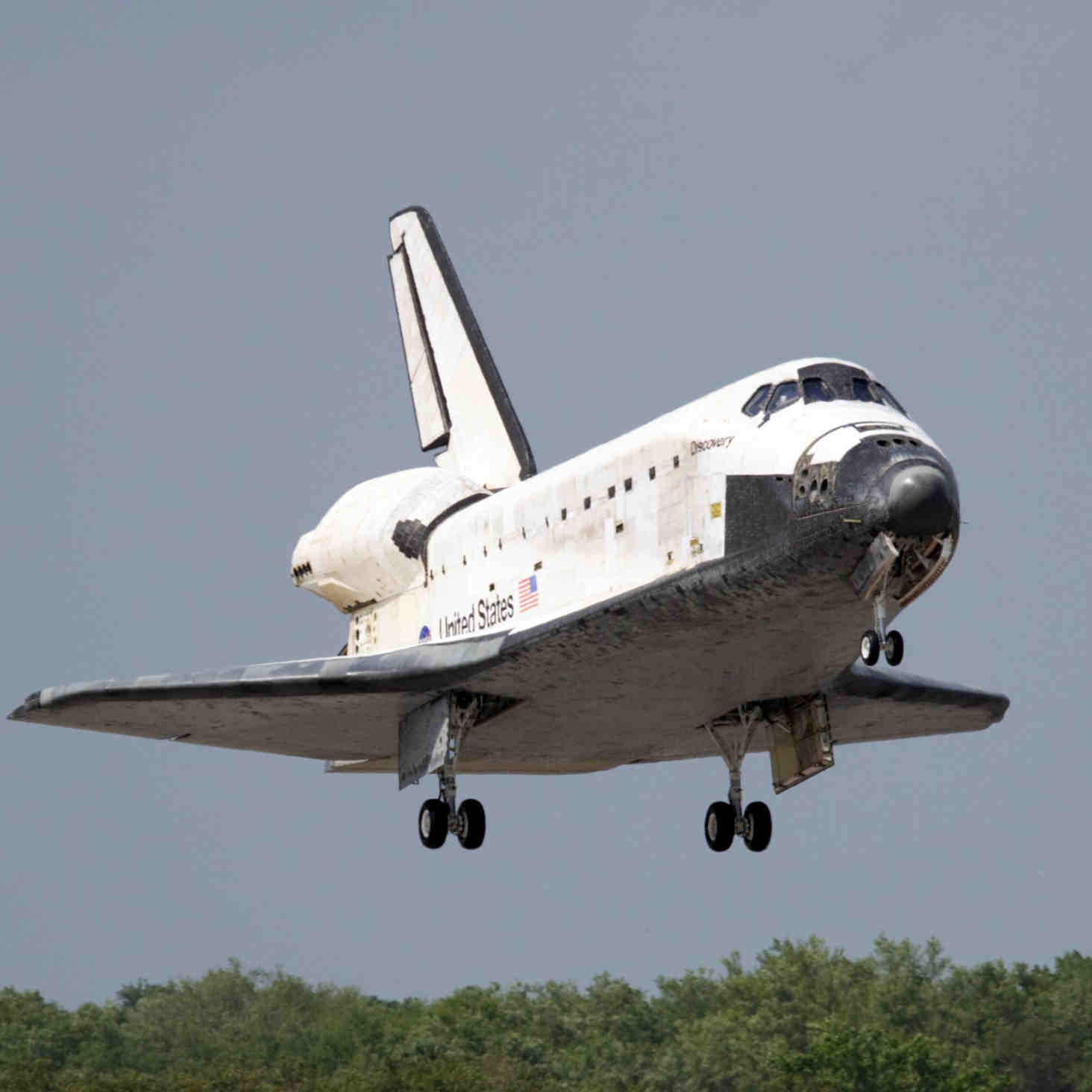 Small circular image of a space shuttle, called Discovery, landing. (Source: NASA).