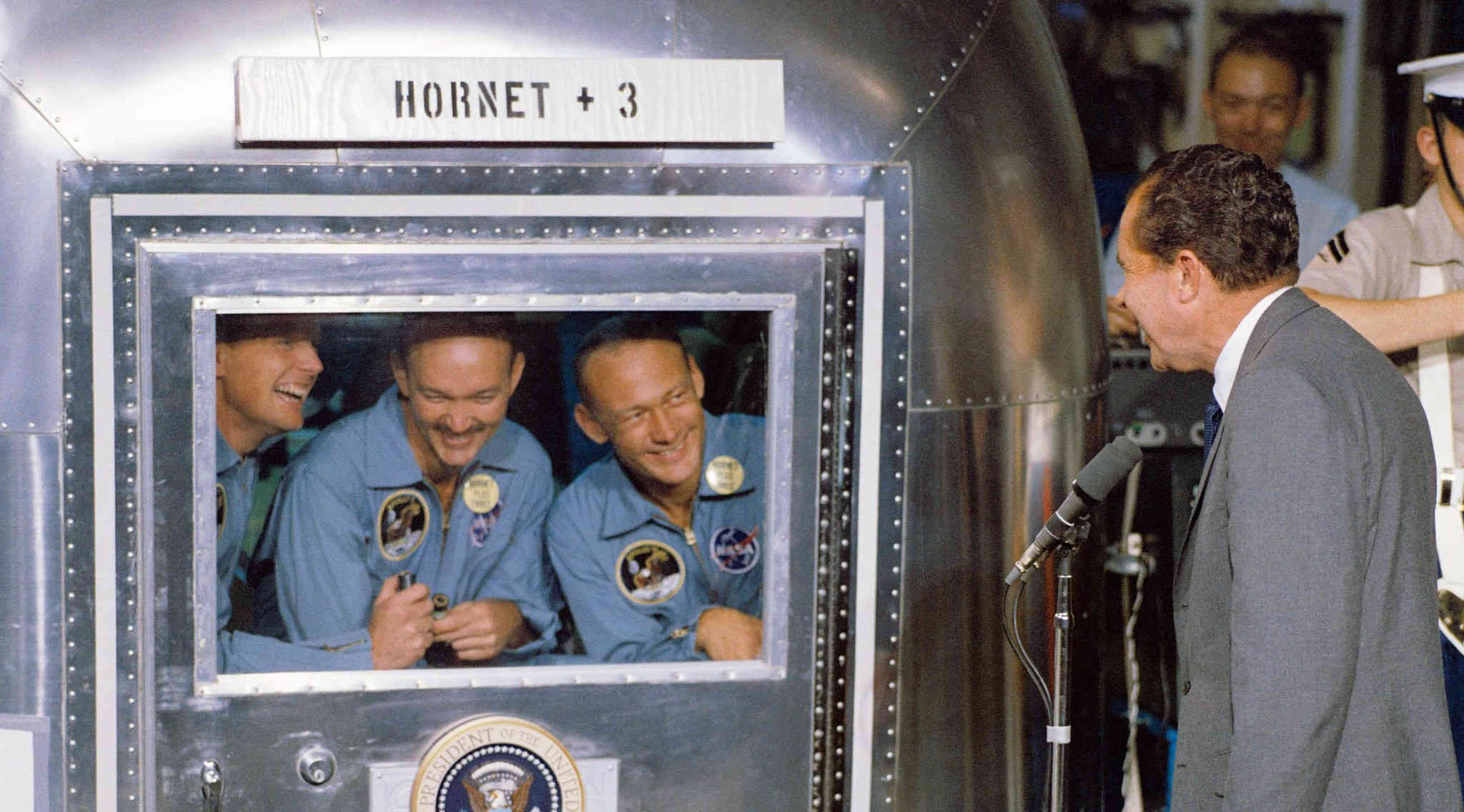 The Apollo 11 crew in the mobile quarantine facility, being visited by US President Richard Nixon. (Source: NASA on The Commons)